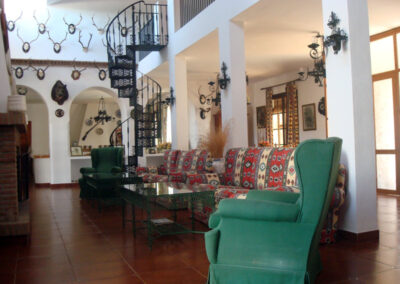 Salón amplio de Casa Rural La Calera con escalera que conduce a la segunda planta