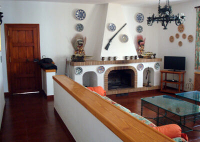 Salón acogedor de Casa Rural La Calera con chimenea, creando un ambiente cálido y rústico